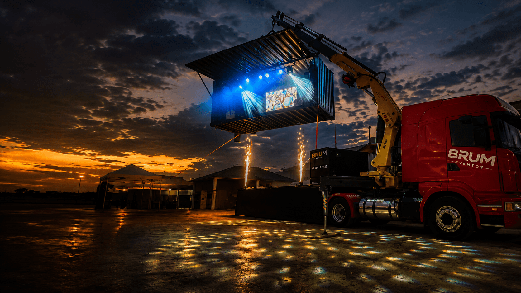 Caminhão da Brum Eventos erguendo o palco-container ao entardecer, LED e iluminação ativos